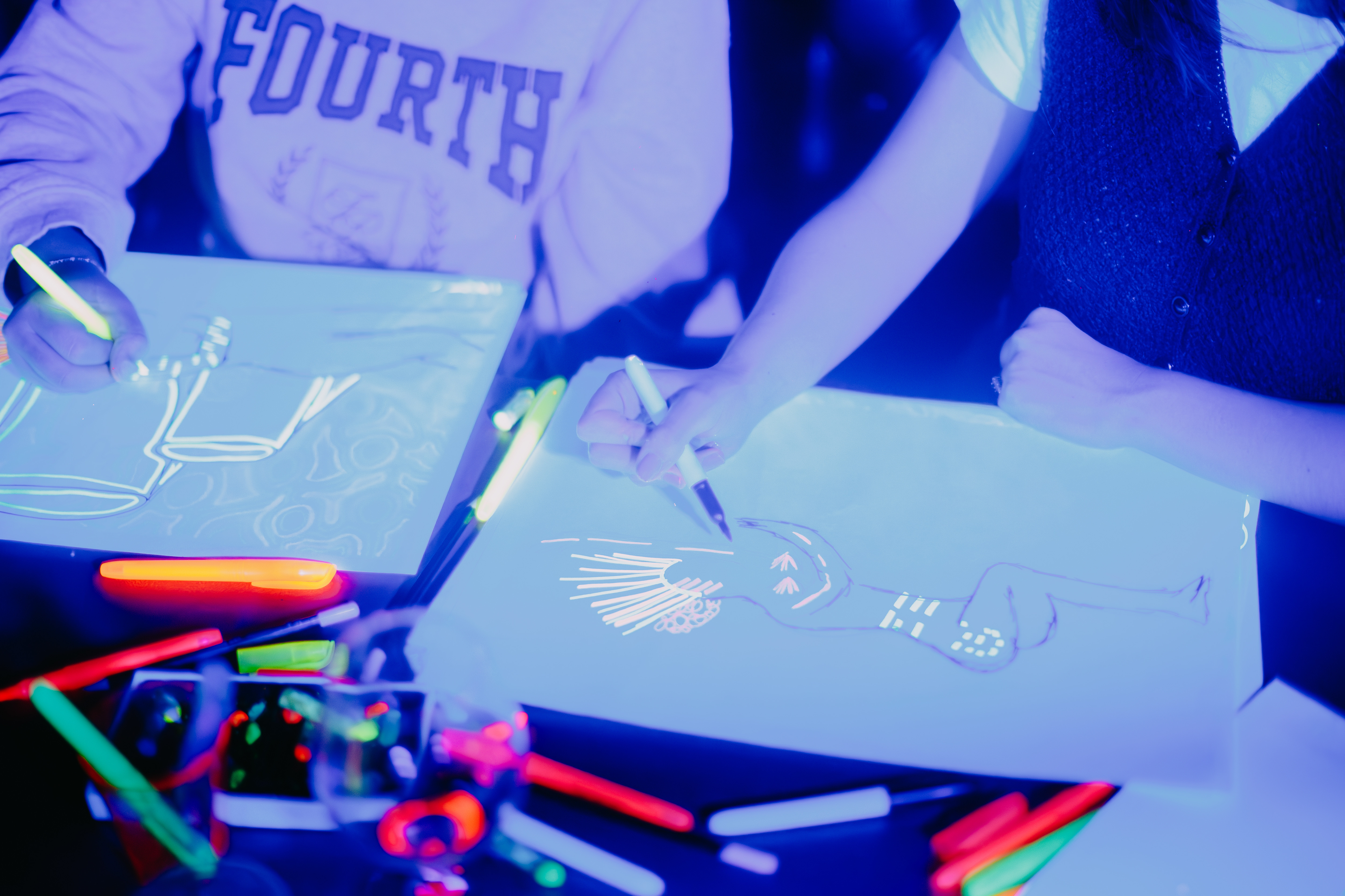 A person posing at a neon life drawing class